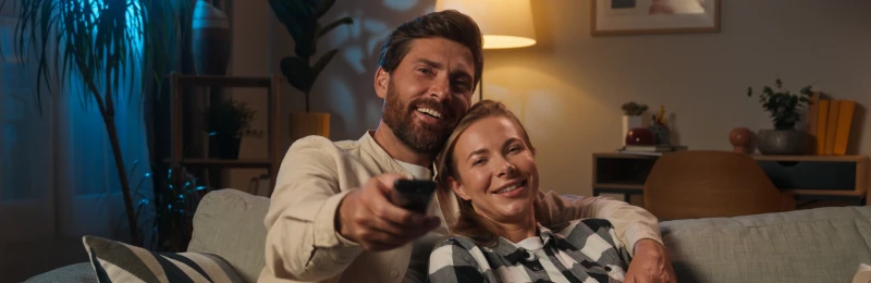 coppia felice mentre guarda la televisione dopo aver sottoscritto un contratto per la fornitura di energia elettrica e gas con Enel